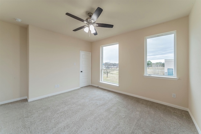 carpeted spare room with ceiling fan