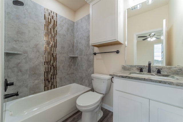 full bathroom featuring toilet, wood-type flooring, tiled shower / bath combo, ceiling fan, and vanity