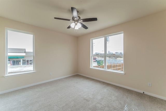 carpeted spare room with ceiling fan