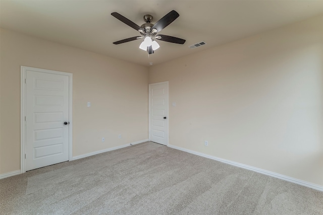 empty room featuring ceiling fan and light carpet