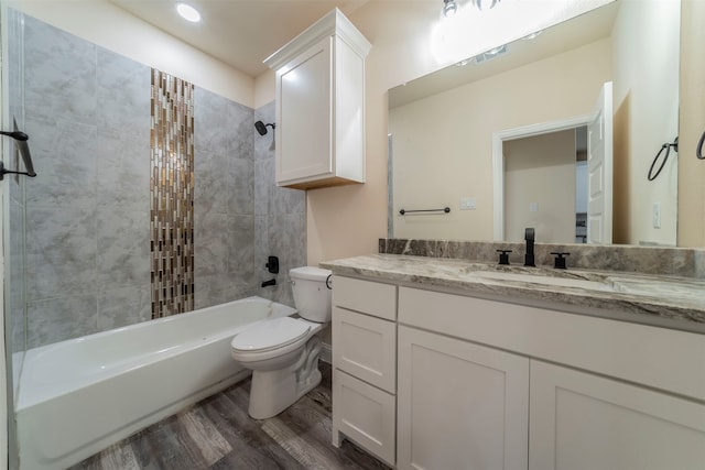 full bathroom featuring tiled shower / bath, toilet, hardwood / wood-style flooring, and vanity