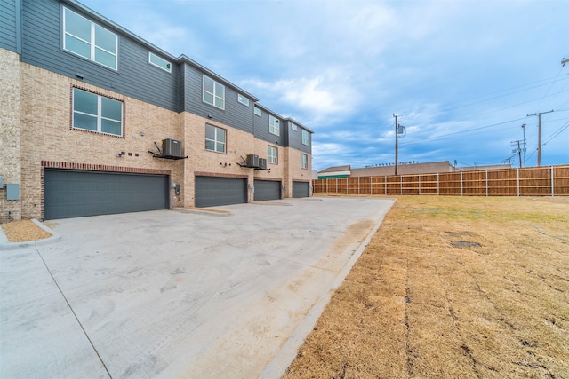 view of side of property featuring a garage and central AC unit