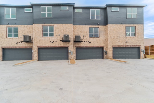 townhome / multi-family property with cooling unit and a garage