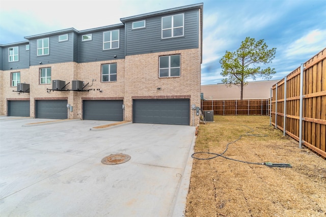 view of front of house featuring a garage and central AC