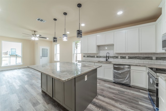 kitchen featuring light hardwood / wood-style flooring, stainless steel appliances, a center island, ceiling fan, and white cabinets