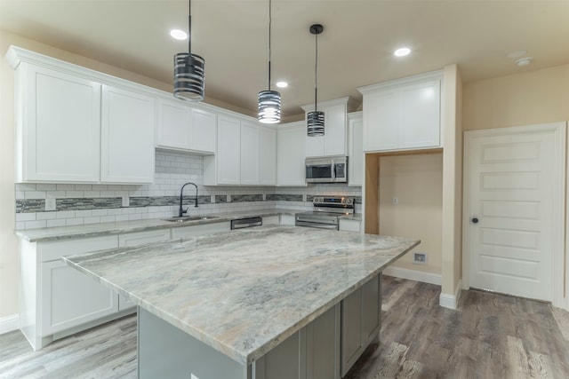 kitchen with a center island, appliances with stainless steel finishes, and white cabinetry