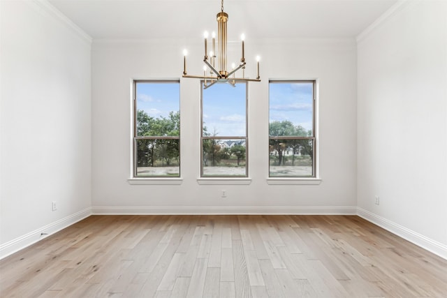 empty room featuring crown molding, a notable chandelier, a healthy amount of sunlight, and light wood-type flooring