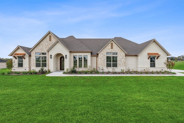 french country inspired facade with a front yard