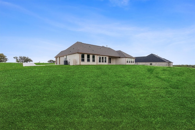 rear view of property with a garage and a lawn