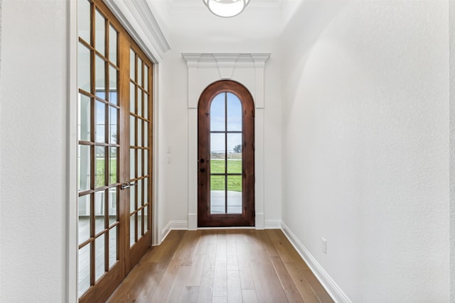 doorway featuring french doors, ornamental molding, and light hardwood / wood-style flooring