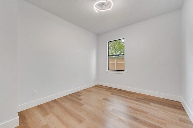 unfurnished room with light wood-type flooring and baseboards