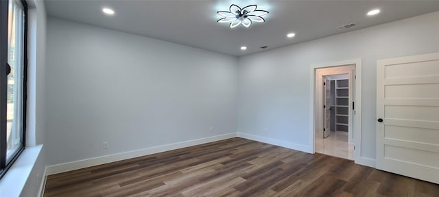 empty room featuring recessed lighting, visible vents, baseboards, and dark wood finished floors