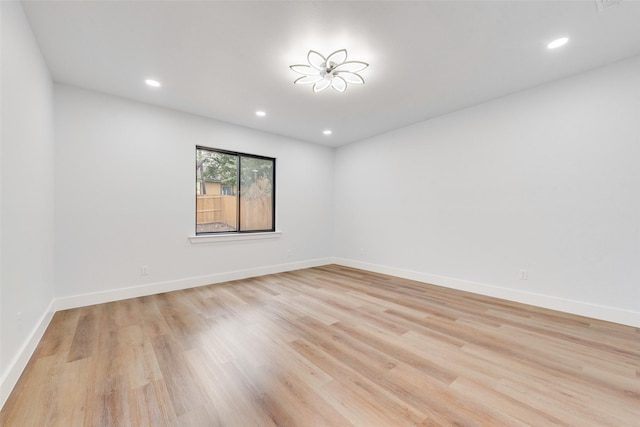 spare room featuring light wood-style flooring, recessed lighting, and baseboards