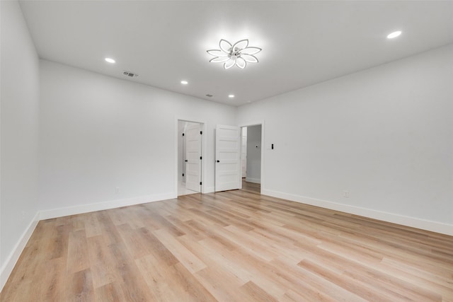 spare room featuring visible vents, recessed lighting, light wood-type flooring, and baseboards