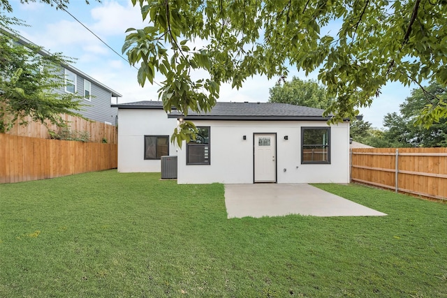 back of house with a fenced backyard, stucco siding, a yard, and central AC