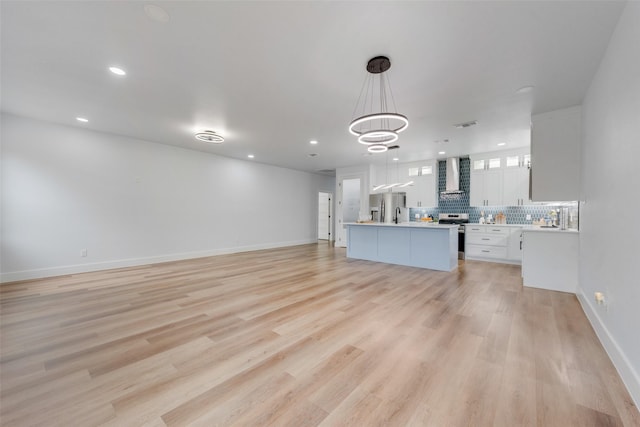 unfurnished living room with visible vents, recessed lighting, light wood-type flooring, and baseboards