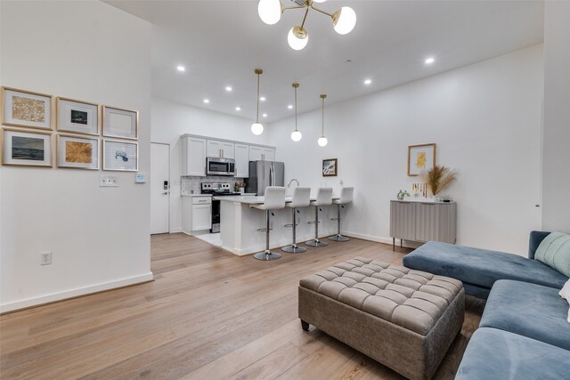 living room with an inviting chandelier and light hardwood / wood-style floors