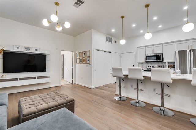 living room featuring an inviting chandelier and light hardwood / wood-style floors