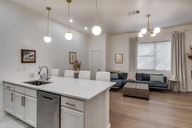 kitchen with dishwasher, pendant lighting, sink, and white cabinetry