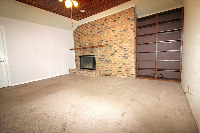 unfurnished living room featuring wood ceiling, brick wall, ceiling fan, and a fireplace