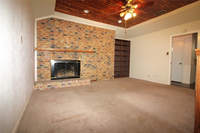 unfurnished living room featuring carpet flooring, ceiling fan, wood ceiling, and a brick fireplace