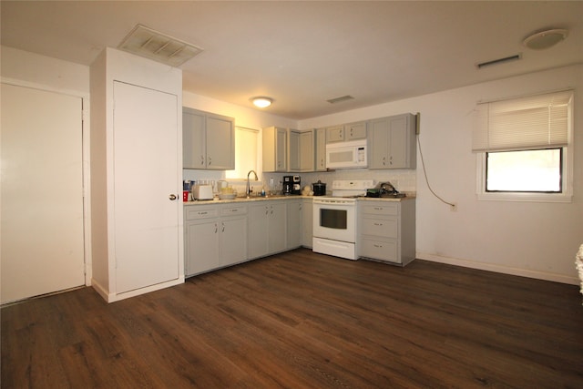 kitchen featuring white appliances, dark wood-type flooring, sink, gray cabinets, and decorative backsplash