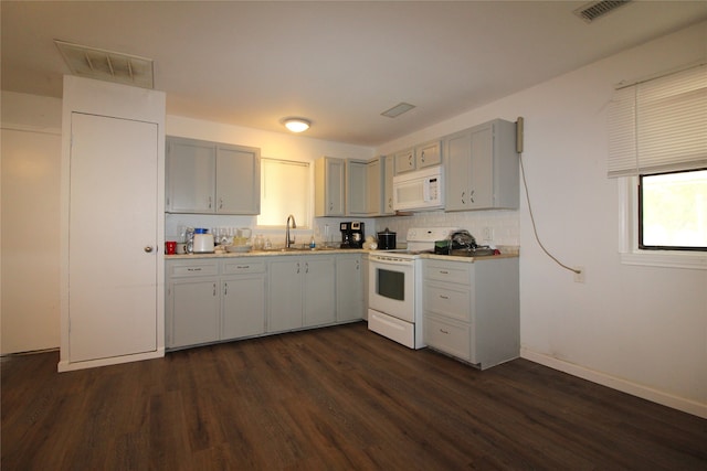 kitchen featuring gray cabinetry, backsplash, white appliances, dark hardwood / wood-style flooring, and sink