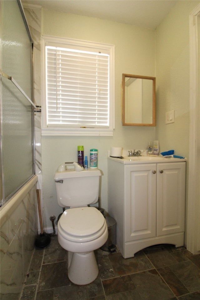 bathroom featuring vanity, toilet, and walk in shower