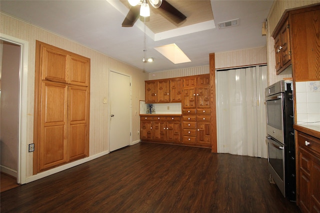 kitchen with crown molding, ceiling fan, dark hardwood / wood-style floors, and a skylight