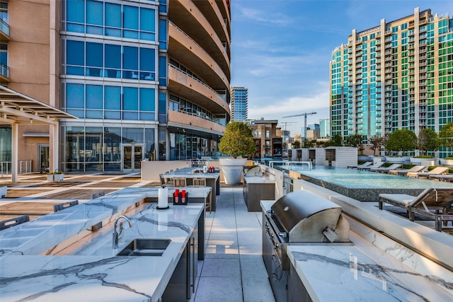 view of patio with an outdoor kitchen, sink, and area for grilling