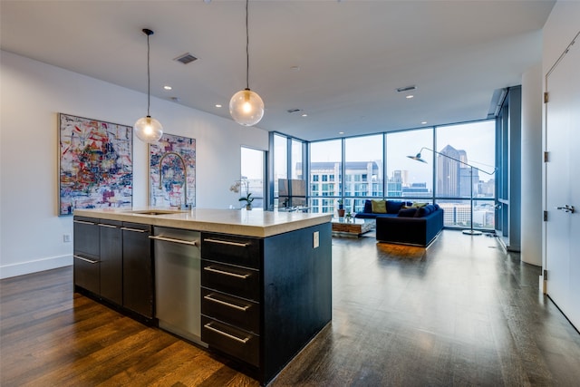 kitchen with a center island with sink, dishwasher, dark wood-type flooring, and pendant lighting