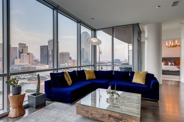 living room featuring a notable chandelier, expansive windows, and wood-type flooring