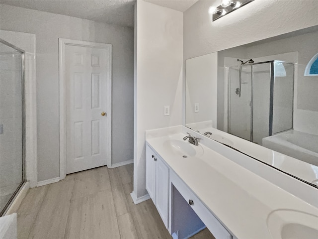 bathroom with a shower with door, hardwood / wood-style flooring, and vanity