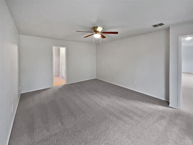 carpeted spare room featuring a textured ceiling and ceiling fan