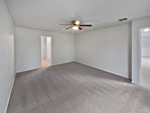 spare room featuring a ceiling fan, carpet, visible vents, and baseboards