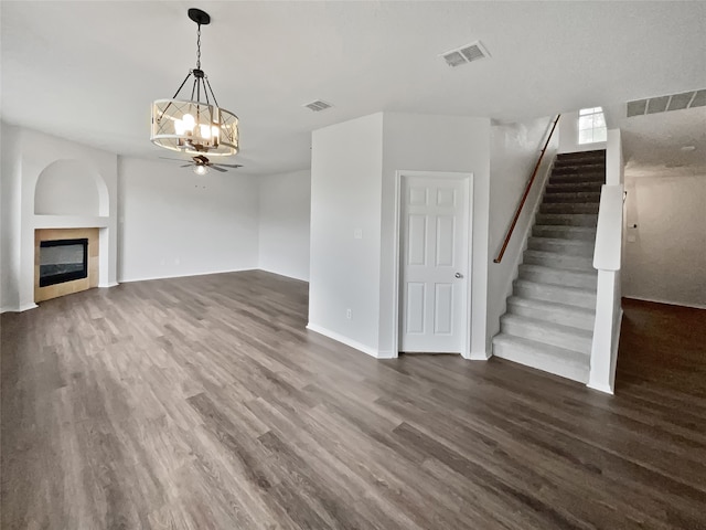 unfurnished living room with dark hardwood / wood-style floors and ceiling fan with notable chandelier