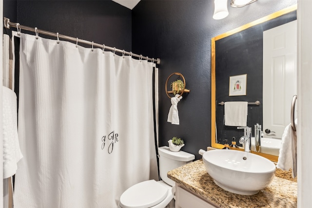 bathroom featuring vanity, toilet, and curtained shower