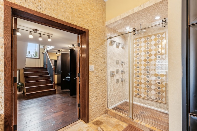 bathroom with a shower with door and hardwood / wood-style flooring