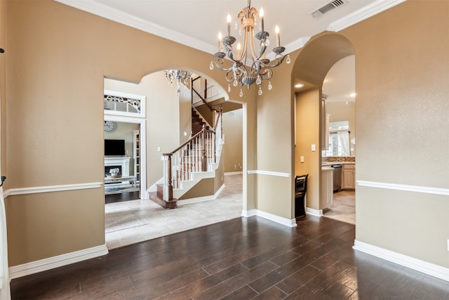 unfurnished room with hardwood / wood-style flooring, crown molding, and a chandelier