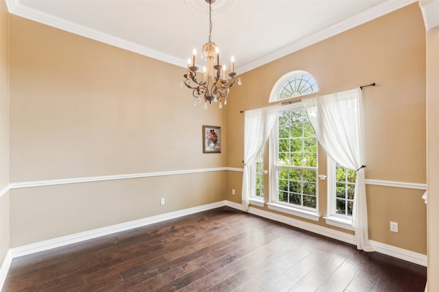 spare room featuring a notable chandelier, crown molding, and dark hardwood / wood-style flooring