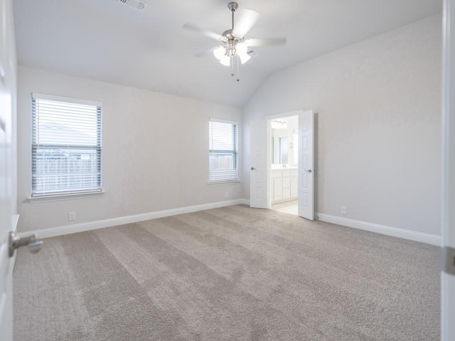 carpeted spare room featuring ceiling fan and vaulted ceiling