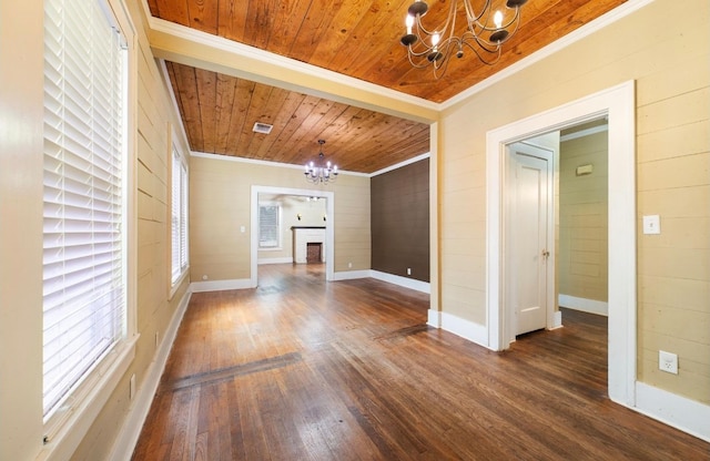 unfurnished living room featuring dark hardwood / wood-style floors, ornamental molding, a brick fireplace, wooden ceiling, and an inviting chandelier