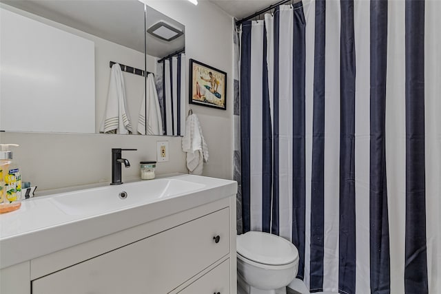 bathroom featuring a shower with shower curtain, toilet, and vanity