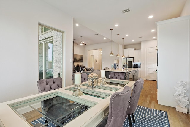 dining room featuring ceiling fan, light hardwood / wood-style flooring, and sink