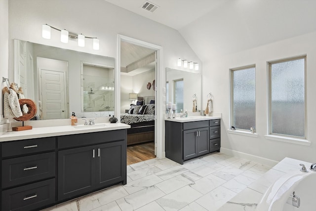 bathroom featuring independent shower and bath, vanity, and vaulted ceiling