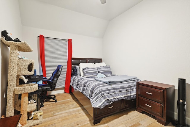 bedroom featuring light wood-type flooring, vaulted ceiling, and ceiling fan