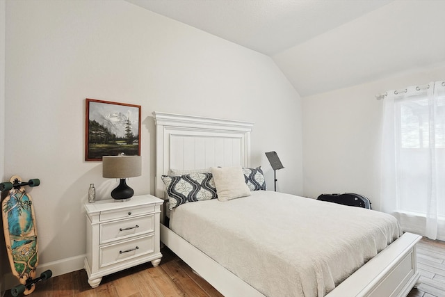 bedroom with lofted ceiling and hardwood / wood-style flooring