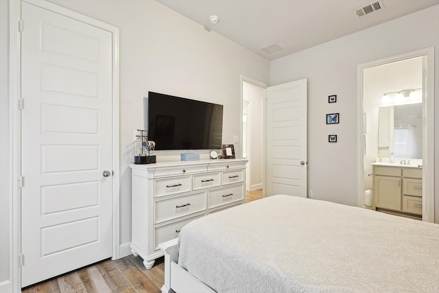 bedroom featuring light wood-type flooring and connected bathroom