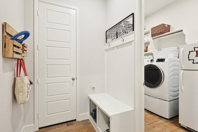 laundry area with light hardwood / wood-style flooring and washer / dryer