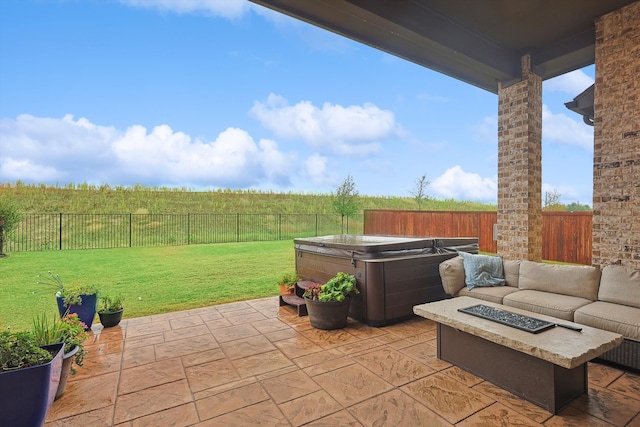 view of patio / terrace with a hot tub and an outdoor living space with a fire pit